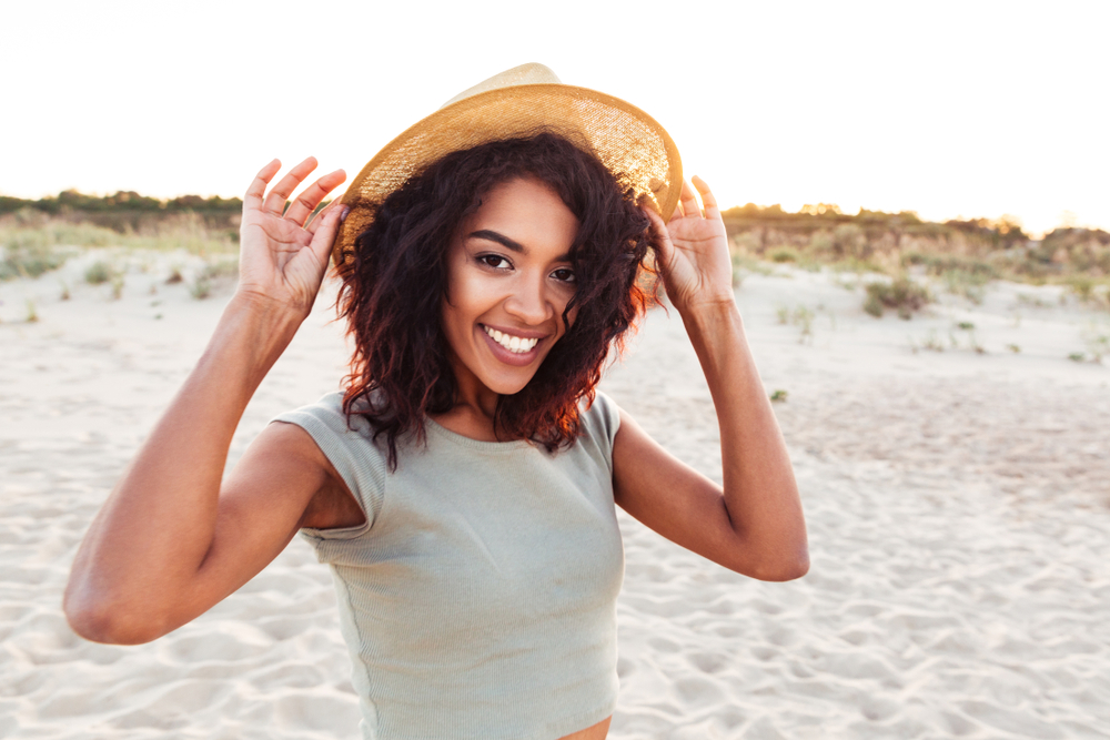 A young woman is proud of her smile thanks to cosmetic dentistry and dental crowns.