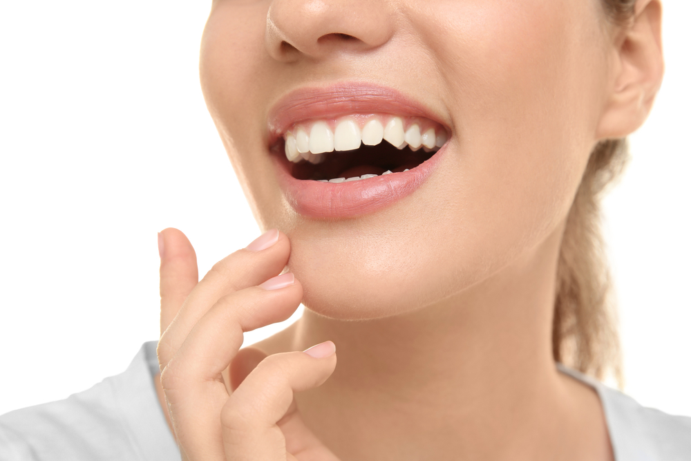 a woman smiles following a successful oral surgery