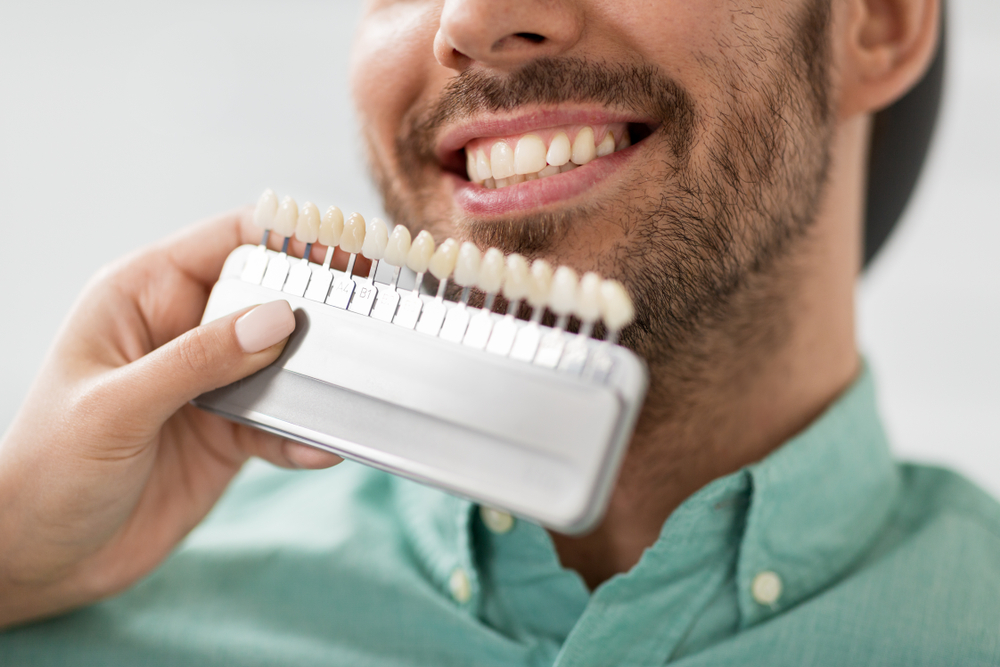 a man compares his teeth to new porcelain veneers